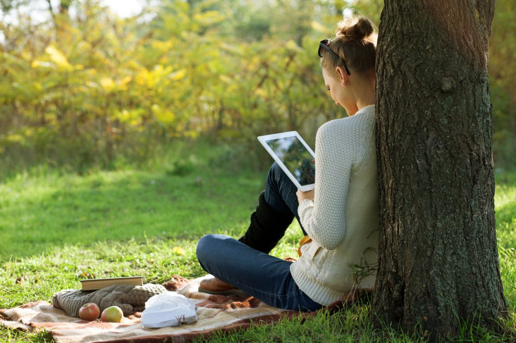 Woman Studying at Park on iPad